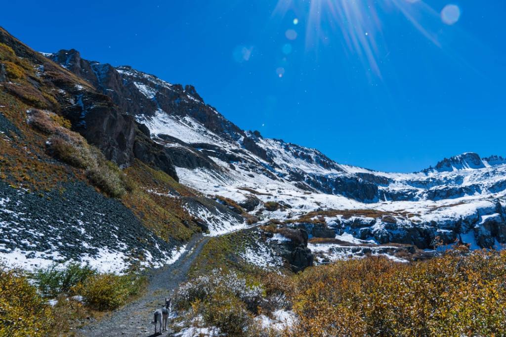 the sun shines brightly over a snowy mountain