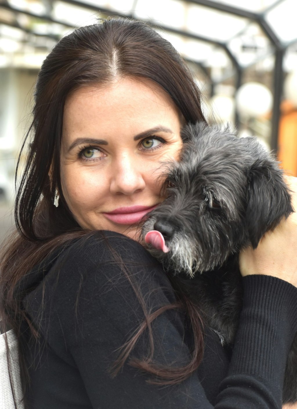 a woman holding a small dog in her arms